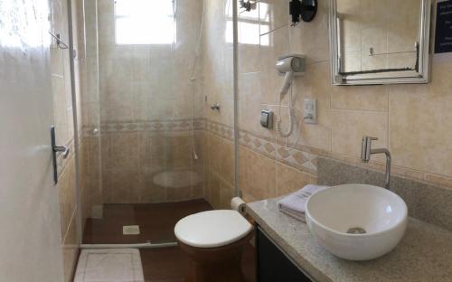 La salle de bains est pourvue de toilettes, d'un lavabo et d'une douche. dans l'établissement MONTE LÍBANO HOTEL II, à Florianópolis