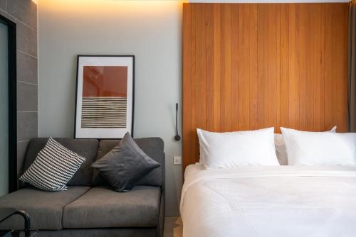 a bedroom with a bed and a couch at Woodstory Boutique Hotel in Bangkok