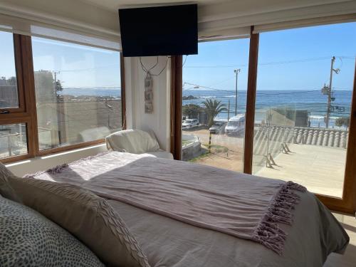 1 dormitorio con cama y vistas al océano en Gran casa maitencillo frente al mar, en Maitencillo