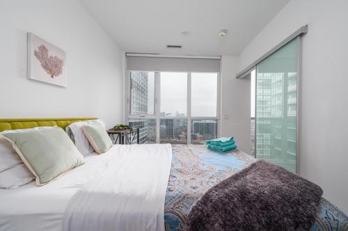 a bedroom with a large bed and a large window at Luxury properties close to Eaton Center! in Toronto