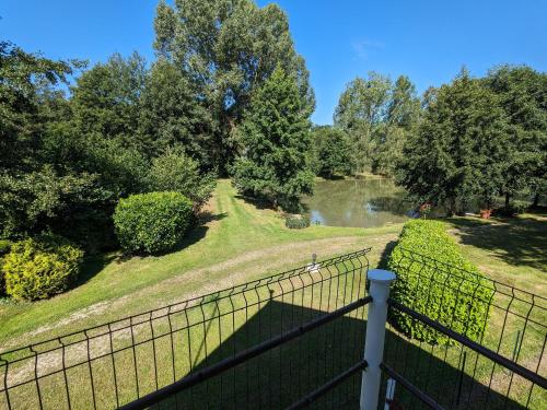 a view from the balcony of a house with a fence at Gîte lumineux avec jardin paisible entre Montargis et Sully-sur-Loire, idéal familles et pros - FR-1-590-373 in Montereau