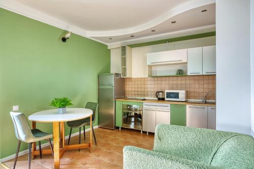 a kitchen with a table and chairs and a table and a counter at Arbat апартаменты в центре города - выбор для туриста и деловых поездок in Almaty