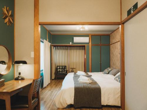 a bedroom with a bed and a desk and a desk at 駅徒歩1分 静かな阿倍野の一棟貸し 長期滞在向け 最大6名 Tsubame INN Abeno in Osaka