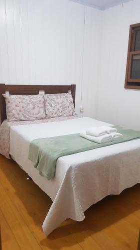 1 dormitorio con 1 cama grande con sábanas blancas en Casa da Mari, en Canela