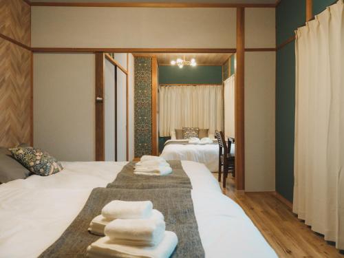 a hotel room with two beds with towels on them at 駅徒歩1分 静かな阿倍野の一棟貸し 長期滞在向け 最大6名 Tsubame INN Abeno in Osaka