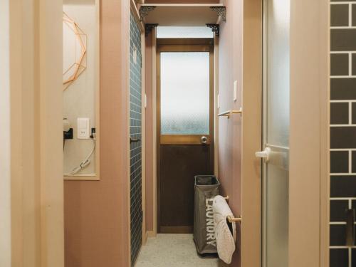 a hallway with a door leading to a bathroom at 駅徒歩1分 静かな阿倍野の一棟貸し 長期滞在向け 最大6名 Tsubame INN Abeno in Osaka