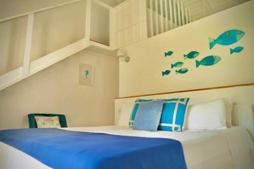 a bedroom with a bed with blue sheets and fish decals at PUNTA POPY Boutique HOTEL in Las Terrenas
