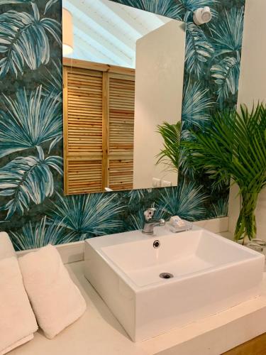a bathroom with a white sink and a mirror at PUNTA POPY BOUTIQUE HOTEL - Adults Only in Las Terrenas