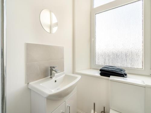 a white bathroom with a sink and a mirror at Apartment Three - Uk44286 in Arbroath