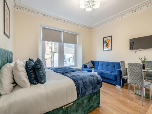 a bedroom with a large bed and a blue couch at Apartment Four - Uk44287 in Arbroath