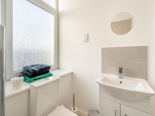 La salle de bains blanche est pourvue d'un lavabo et d'un miroir. dans l'établissement Apartment Four - Uk44287, à Arbroath