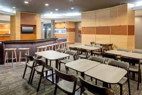 a restaurant with tables and chairs and a bar at SpringHill Suites Columbus in Columbus