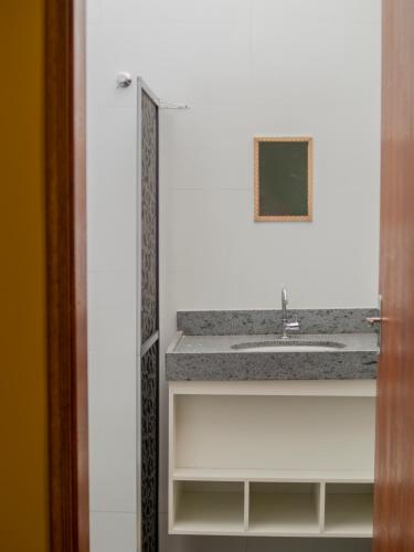 a bathroom counter with a sink and a mirror at Aconchego Flats em Olímpia in Olímpia