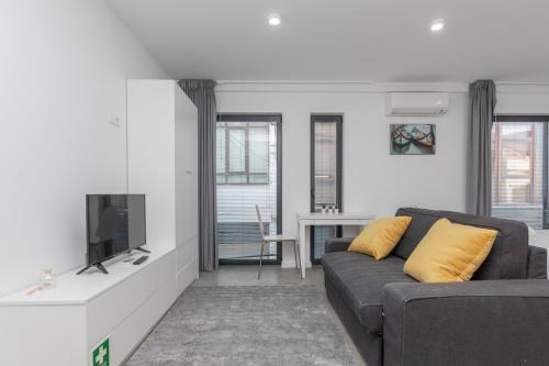 a living room with a couch and a tv at AveiNest - Your Studio in Aveiro in Aveiro