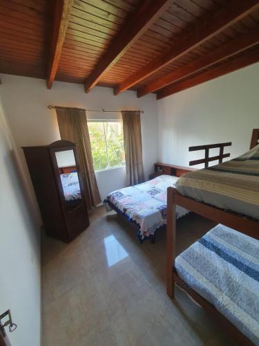 a bedroom with two beds and a mirror at Casa Rural Doña Blanca in Samaipata