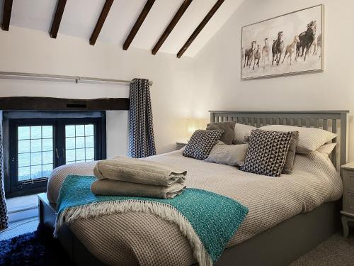 a bedroom with a bed with pillows on it at Denver Cottage - Uk46029 in Monyash