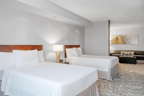 a hotel room with two beds and a couch at SpringHill Suites Terre Haute in Terre Haute
