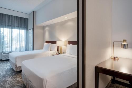 a hotel room with two beds and a desk at SpringHill Suites Terre Haute in Terre Haute