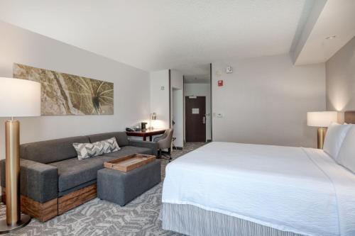 een hotelkamer met een bed en een bank bij SpringHill Suites Terre Haute in Terre Haute