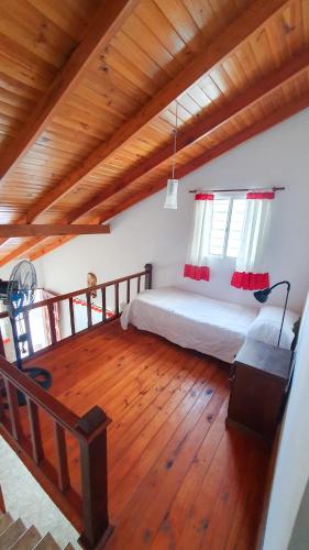 1 dormitorio con 1 cama y suelo de madera en La Mar en Mar de Ajó
