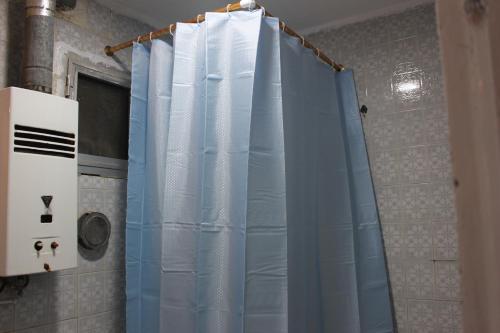 y baño con ducha y cortina azul. en Entire rental unit in New Cairo, Egypt en El Cairo