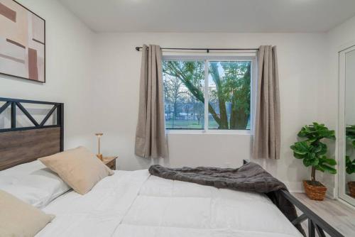 a bedroom with a large white bed and a window at Downtown Modern Cozy Apartment in Dallas