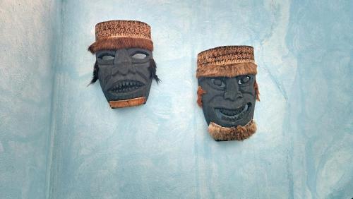 two masks are hanging on a wall at Casa Colonial Estate, Cozumel in Cozumel