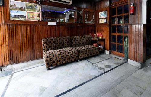 eine Couch in der Mitte eines Zimmers in der Unterkunft OYO Hotel Jammu Palace in Jammu