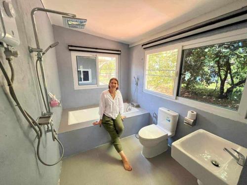 una mujer sentada en una bañera en un baño en family resort, en Ko Phayam