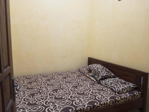 ein Bett mit einer schwarzen und weißen Bettdecke und 2 Kissen in der Unterkunft Sakinah Villa Penataran in Berni