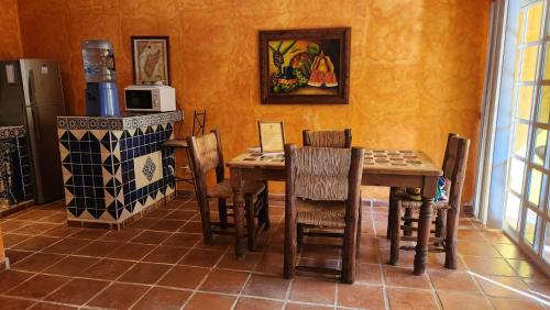 a kitchen with a table and chairs and a stove at Casa Colonial Estate, Cozumel in Cozumel