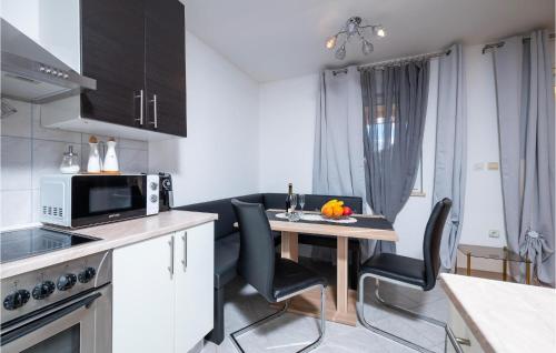 a kitchen with a table with chairs and a microwave at Pet Friendly Apartment In Krsan in Kršan