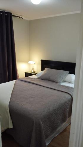 a bedroom with a bed and a lamp on a table at Departamentos Santiago Centro # 402 in Santiago