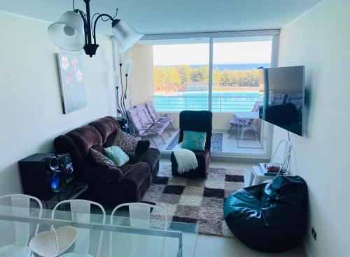 ein Wohnzimmer mit Sofas und einem Glastisch in der Unterkunft Lagunamar las cruces in El Tabo