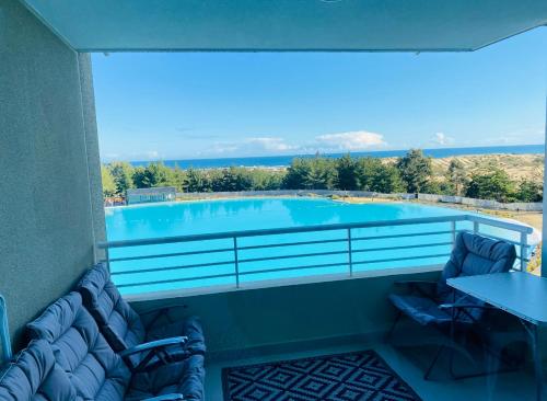 a swimming pool with two chairs and a table at Lagunamar las cruces in El Tabo