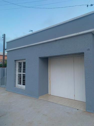 a blue building with two garage doors on it at Casa cinza in São Lourenço do Sul