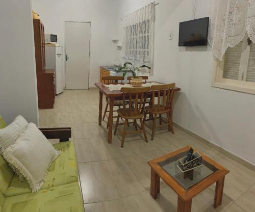 a living room with a table and a couch at Casa cinza in São Lourenço do Sul