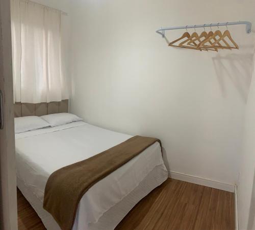 a bedroom with a white bed and a window at Casa cinza in São Lourenço do Sul