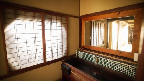 baño con espejo, lavabo y ventanas en Maison d'hôtes KIRISIMIZU - Vacation STAY 40997v, en Nagano