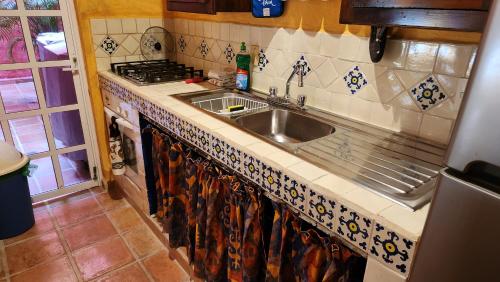 a kitchen counter with a sink and a stove at Casa Colonial Estate, Cozumel in Cozumel