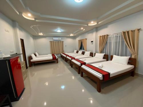 um quarto com várias camas e uma televisão de ecrã plano em Brown Andaman Krabi em Cidade de Krabi