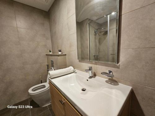 une salle de bain avec un lavabo et des toilettes dans l'établissement Ensuite one bedroom in a 2-bedroom with a shared living room, à Dubaï