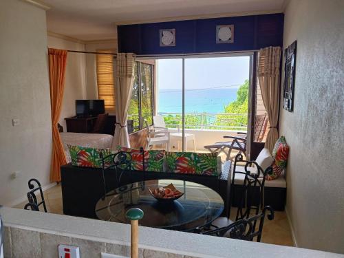 a living room with a table and a view of the ocean at Coral Lane Beach Apartments in Saint James