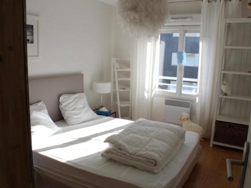 une chambre avec un lit avec des draps blancs et une fenêtre dans l'établissement Fort-Mahon-Plage: À deux pas de la plage, appartement neuf avec balcon et garage - FR-1-482-134, à Fort-Mahon-Plage