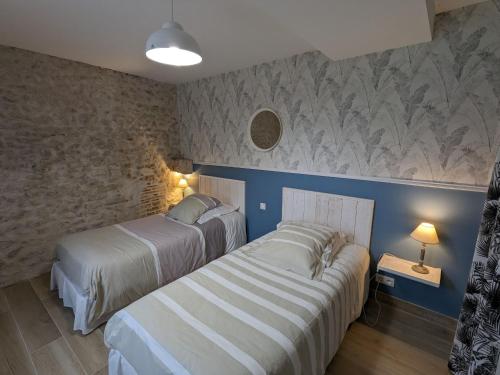 2 camas en un dormitorio con paredes azules en Gîte Traînou, 4 pièces, 6 personnes - FR-1-590-419, en Traînou