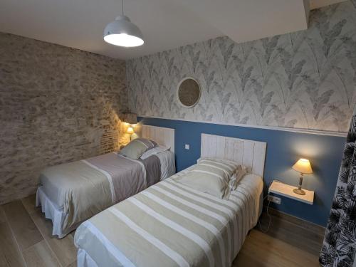 two beds in a bedroom with blue walls at Gîte rénové à la ferme en Val de Loire, proche forêt d'Orléans et canal, vélo, golf, sites touristiques - FR-1-590-419 in Traînou