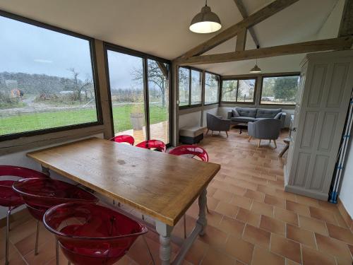 une salle à manger avec une table en bois et des chaises rouges dans l'établissement Gîte rénové à la ferme en Val de Loire, proche forêt d'Orléans et canal, vélo, golf, sites touristiques - FR-1-590-419, à Traînou