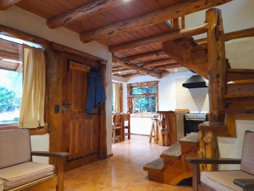 a living room with a loft bed and wooden ceilings at Cabaña El Viaje in San Carlos de Bariloche