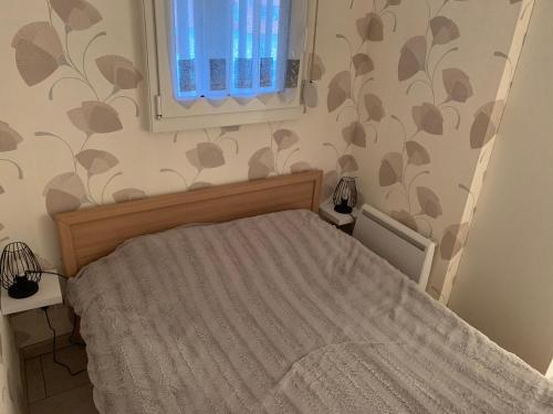 une petite chambre avec un lit et une fenêtre dans l'établissement Coquet Appartement T2, Balcon Sud, Parking Privé, 400m de la Plage - Fort-Mahon-Plage - FR-1-482-135, à Fort-Mahon-Plage