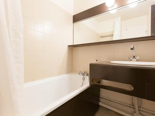 a bathroom with a tub and a sink and a mirror at Appartement Avoriaz, 2 pièces, 5 personnes - FR-1-314-257 in Morzine